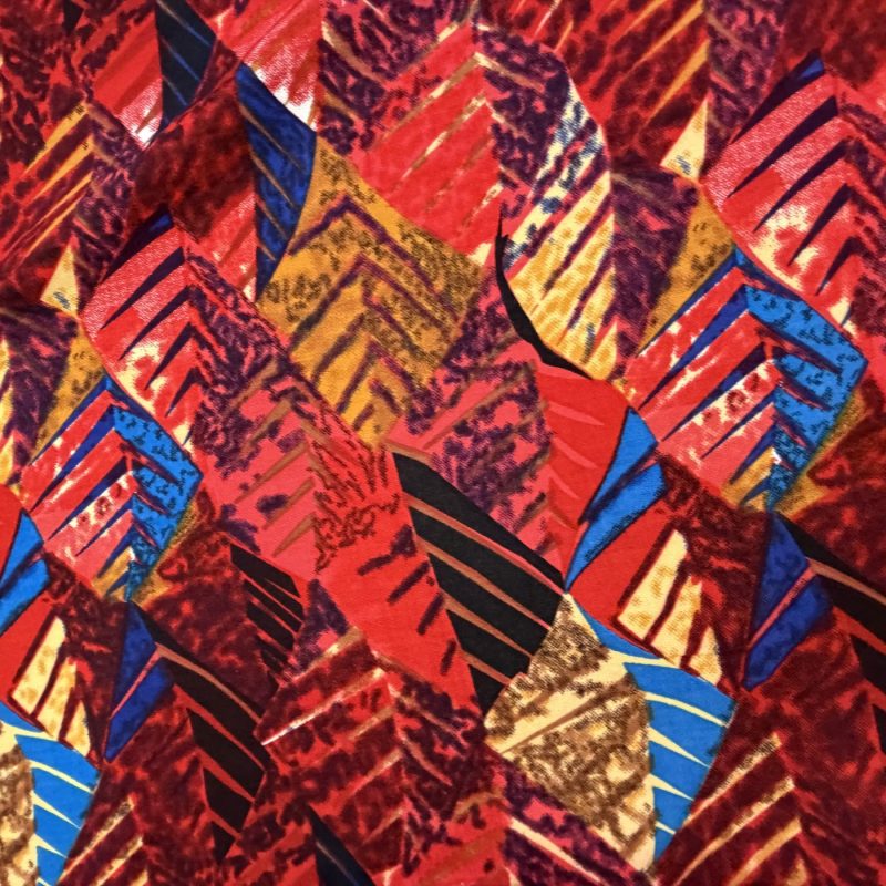 Bedruckter Stoff: federartige Formen in Rot, Blau und Gold