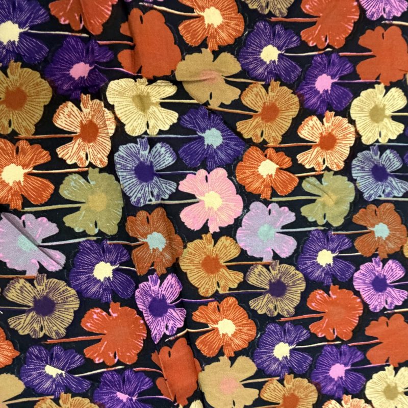 Bedruckter Stoff: Blüten in Orange, Rosa und Ocker auf dunklem Violett