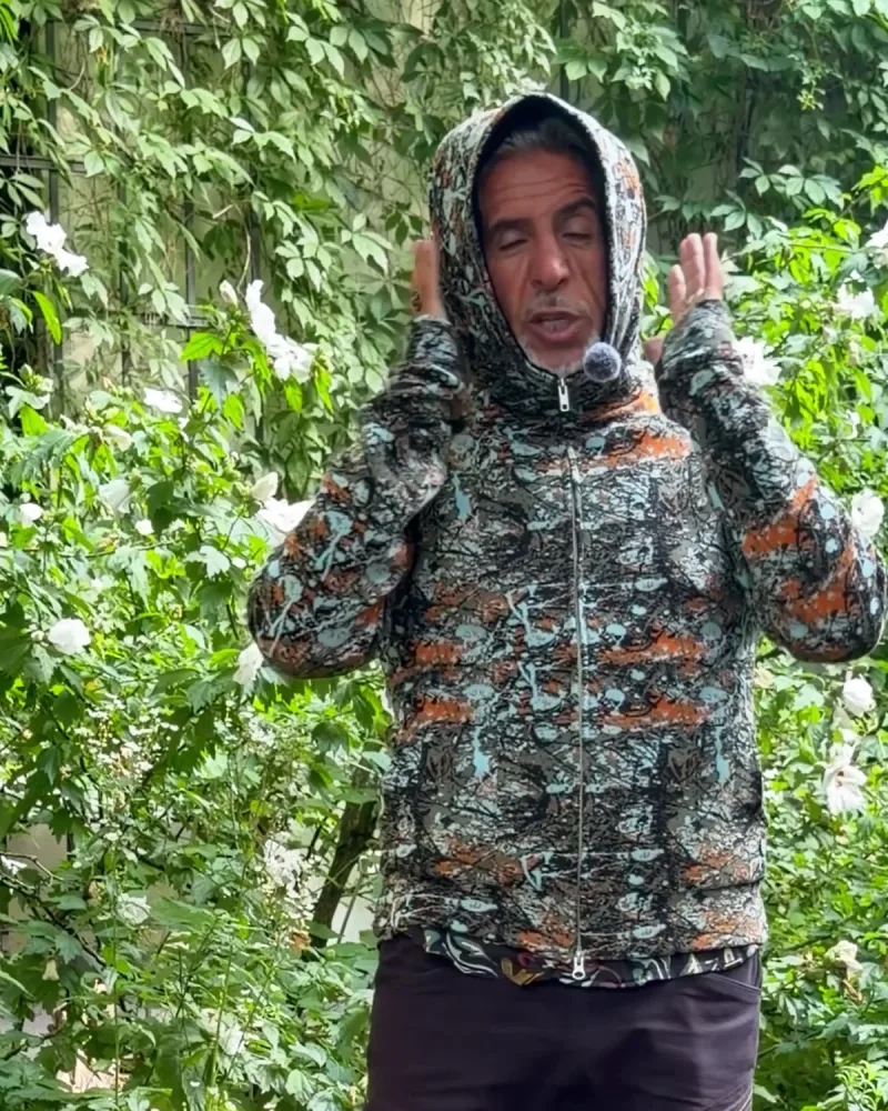 Hamid hat die Kapuze der Jacke Nilo aufgesetzt und bis zum Kinn geschlossen, nur das Gesicht ist frei