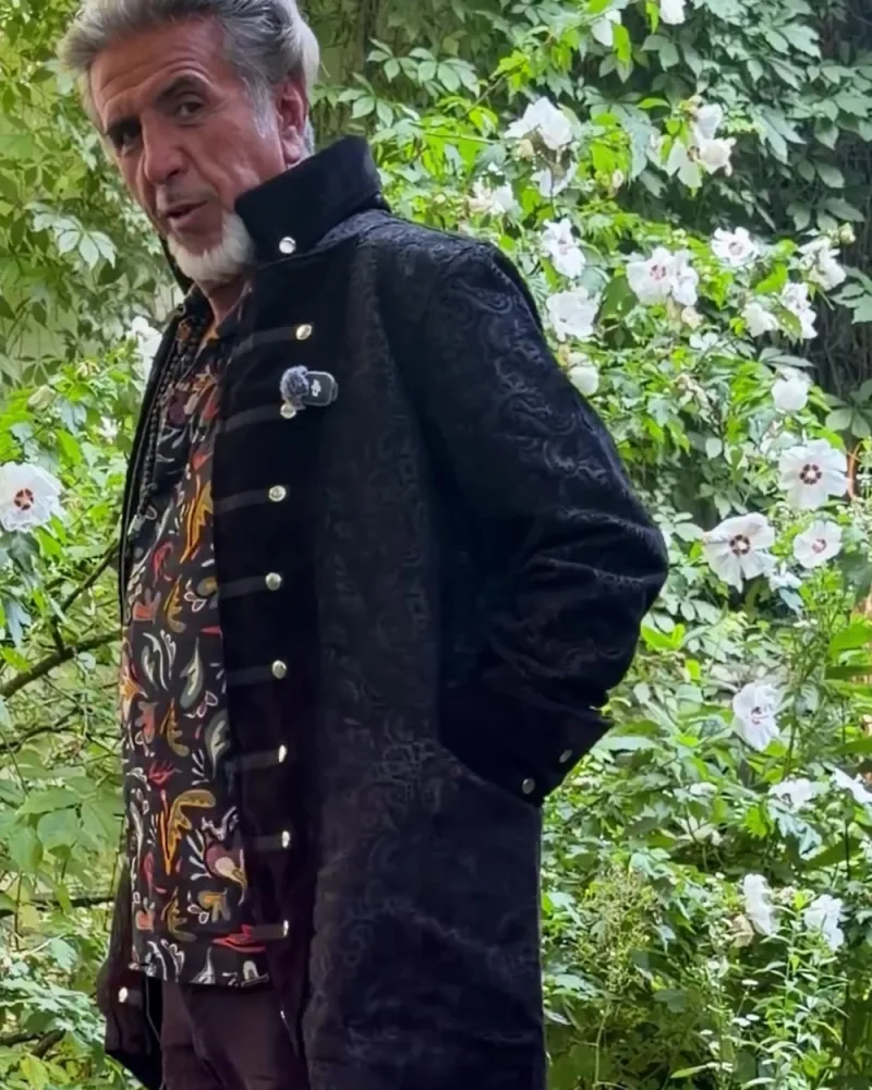 Hamid von der Seite im Mantel Marven, der hinten länger ist als vorn