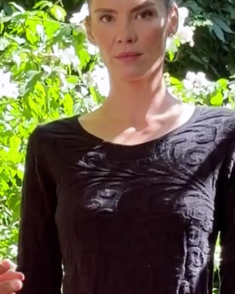 Elisabeth im dunklen Strickkleid Nusha, auf dem Stoff ein erhabenes Ornamentmuster
