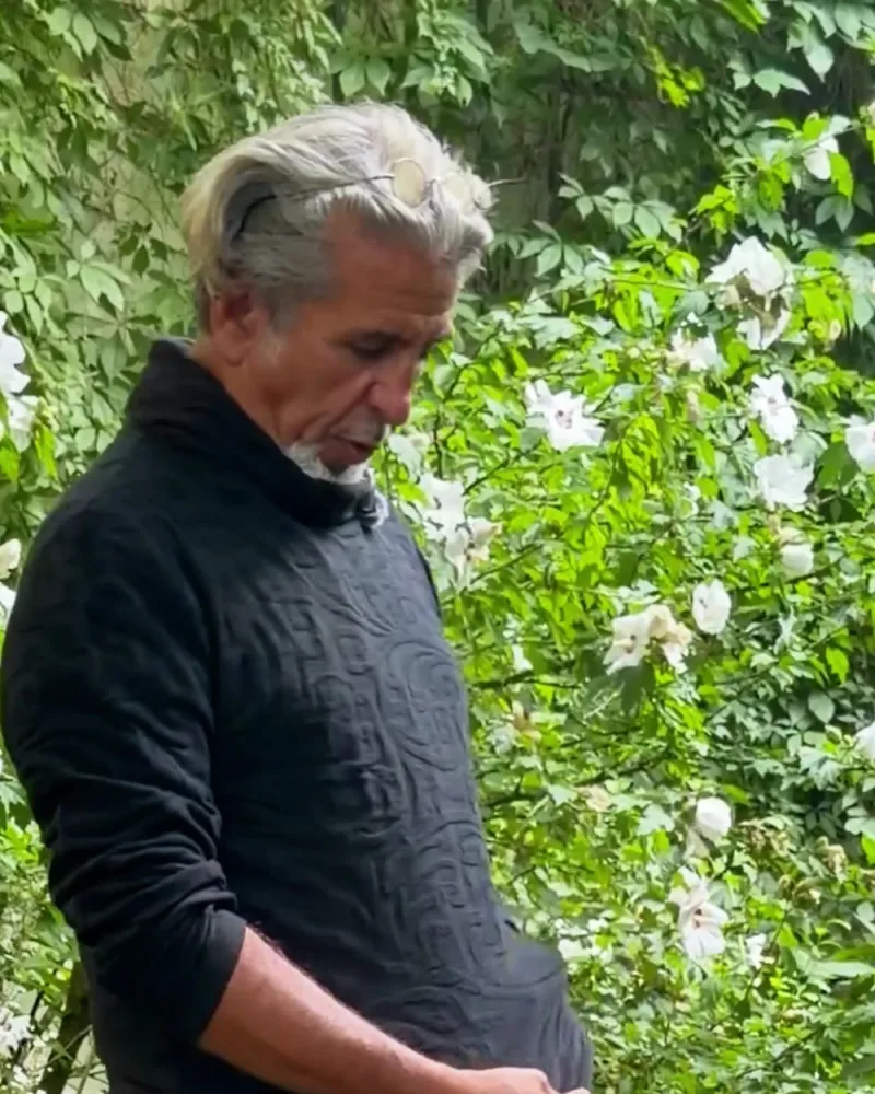 Hamid von der Seite im Pullover Younes, das Strickmuster wirft Schatten