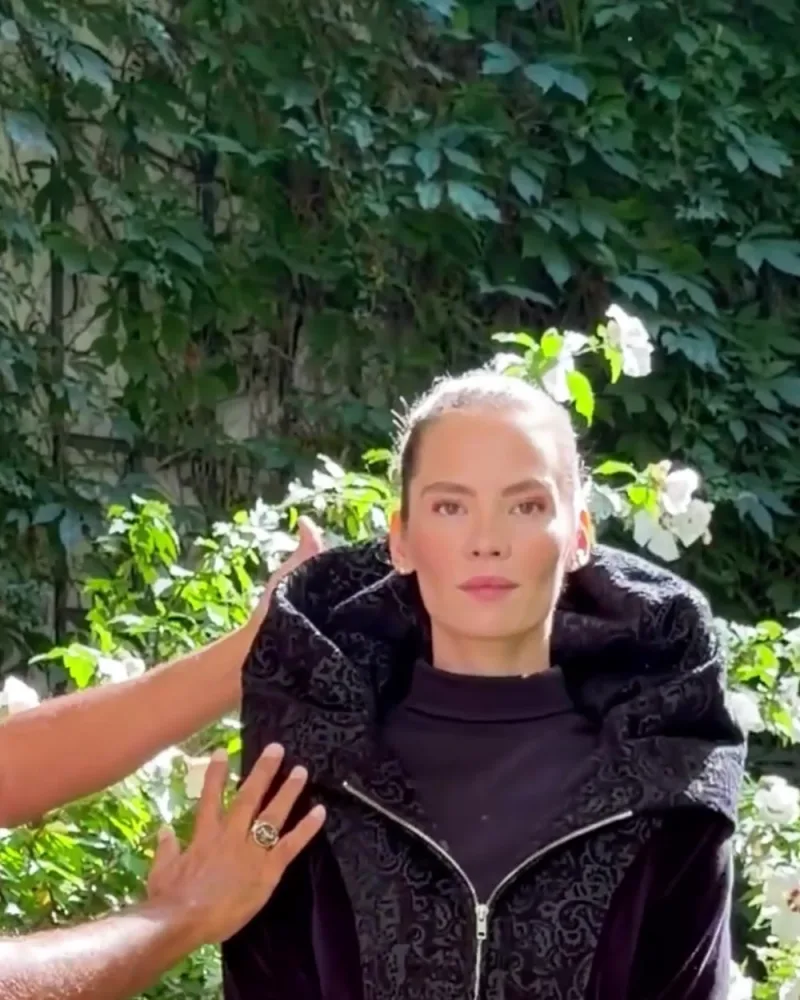 Hamid legt Elisabeth die geraffte Kapuze der Jacke Jessica an
