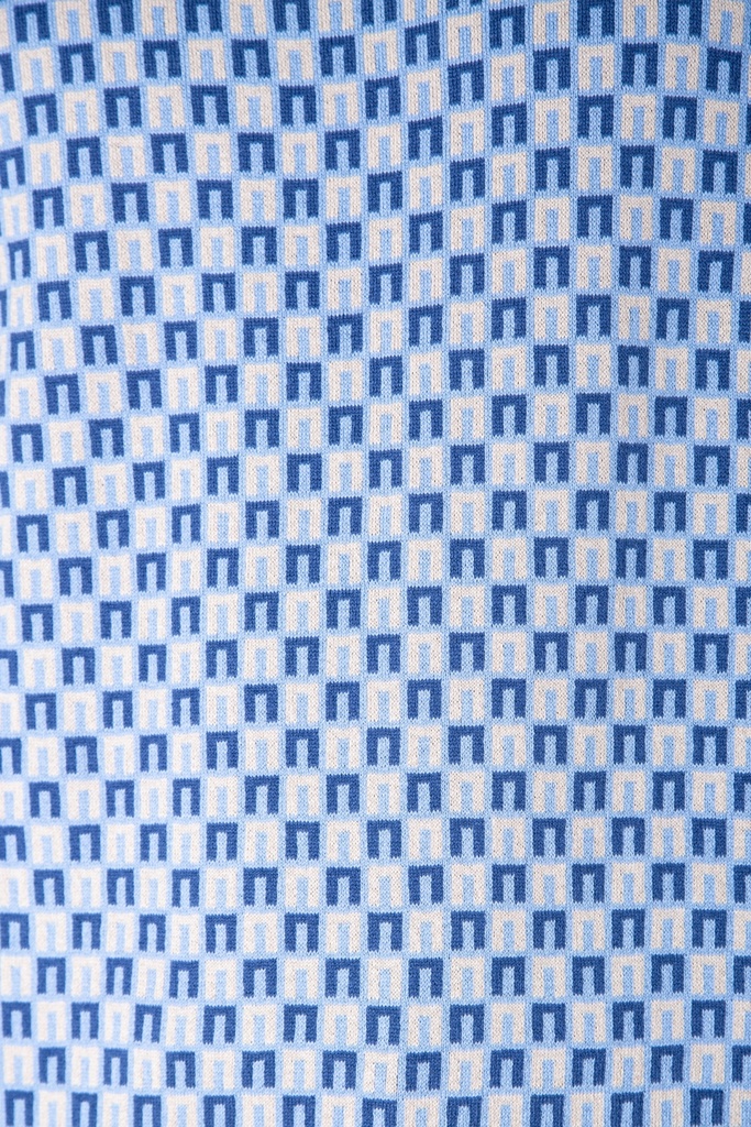 Makroaufnahme des hellblauen Pullover-Stricks: kleine dunkelblaue Rechtecke stehen versetzt auf hellem Grund, die Maschenstruktur ist sichtbar.