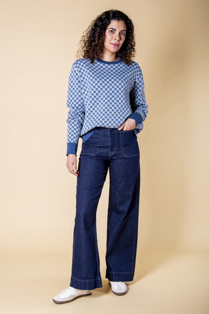 Ganzkörperansicht: hellblauer Pullover aus Strick-Jacquard mit dunkelblauem Rechteckmuster, blauem Rippbund und locker geraden Ärmeln.