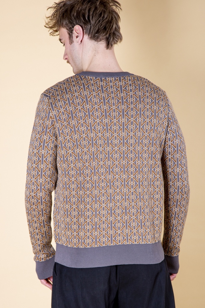 Rückansicht bis zur Hüfte: das dichte Strebenmuster bedeckt den braun-grauen Strick-Jacquard-Pullover bis zum graublauen Rippbund.