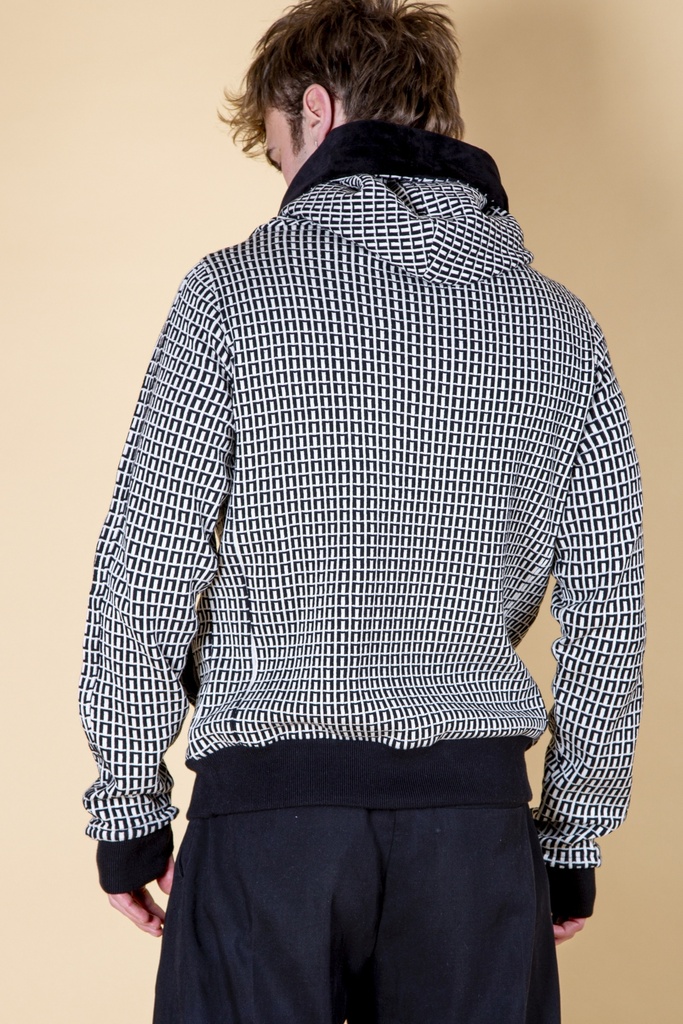 Rückansicht bis zur Hüfte: der schwarz-weiße Pullover aus Strick-Jacquard zeigt ein feines Rechteckmuster über Rücken und Kapuzenschal.