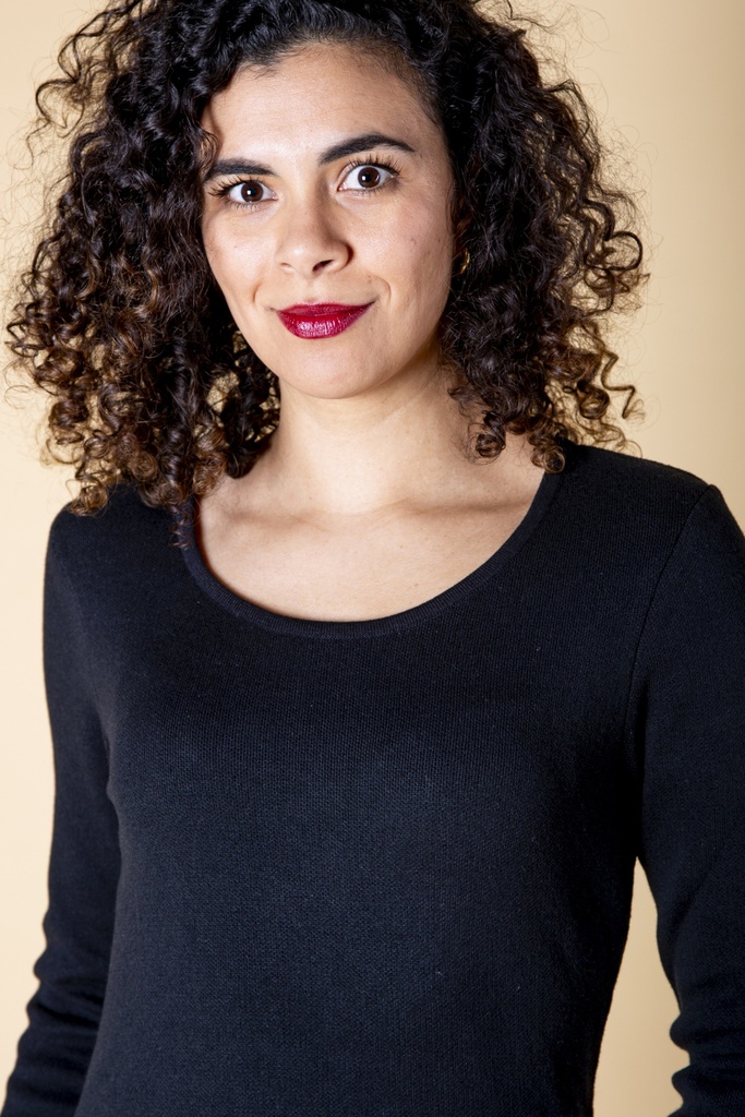 Nahaufnahme von Ausschnitt und Schulter: der schwarze Pullover aus Strick-Jacquard zeigt eine schmale Rippkante am Rundhalsausschnitt und glatten Feinstrick.
