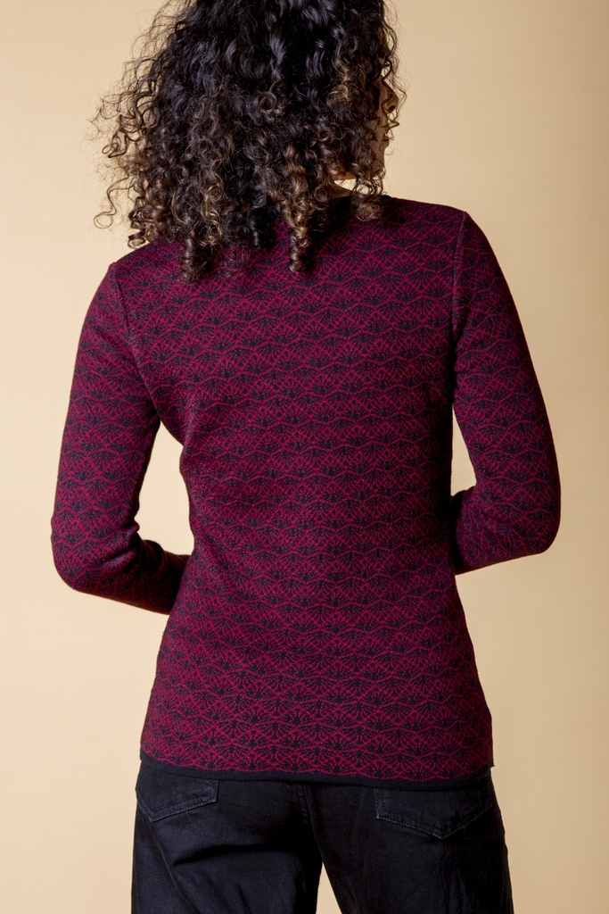 Rückansicht bis zur Hüfte: der dunkelrote Pullover aus Strick-Jacquard zeigt ein durchgehendes schwarzes Rankenmuster und einen geraden dunklen Saum.
