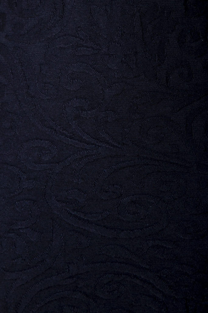 Makroaufnahme des Kleid-Stricks: Ranken und Bögen treten im schwarzen Strick-Jacquard allein durch ihre reliefartige Höhe ohne Farbwechsel hervor.