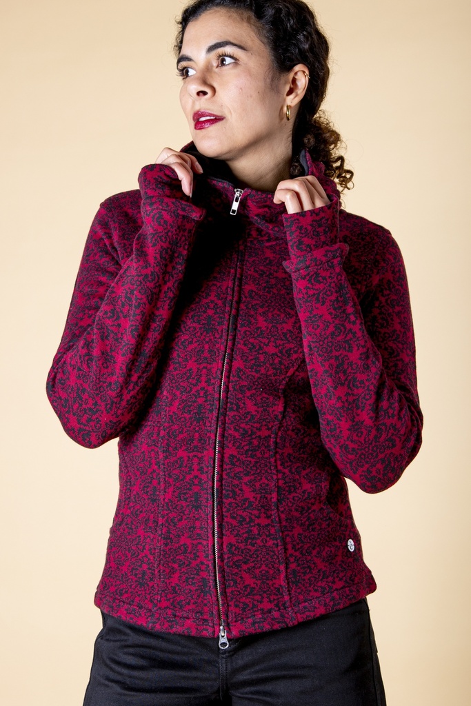 Vorderansicht bis zur Hüfte: dunkelrote Jacke aus Strick-Jacquard mit schwarzem Barockmuster, Reißverschluss und hoch stehendem Kapuzenkragen.