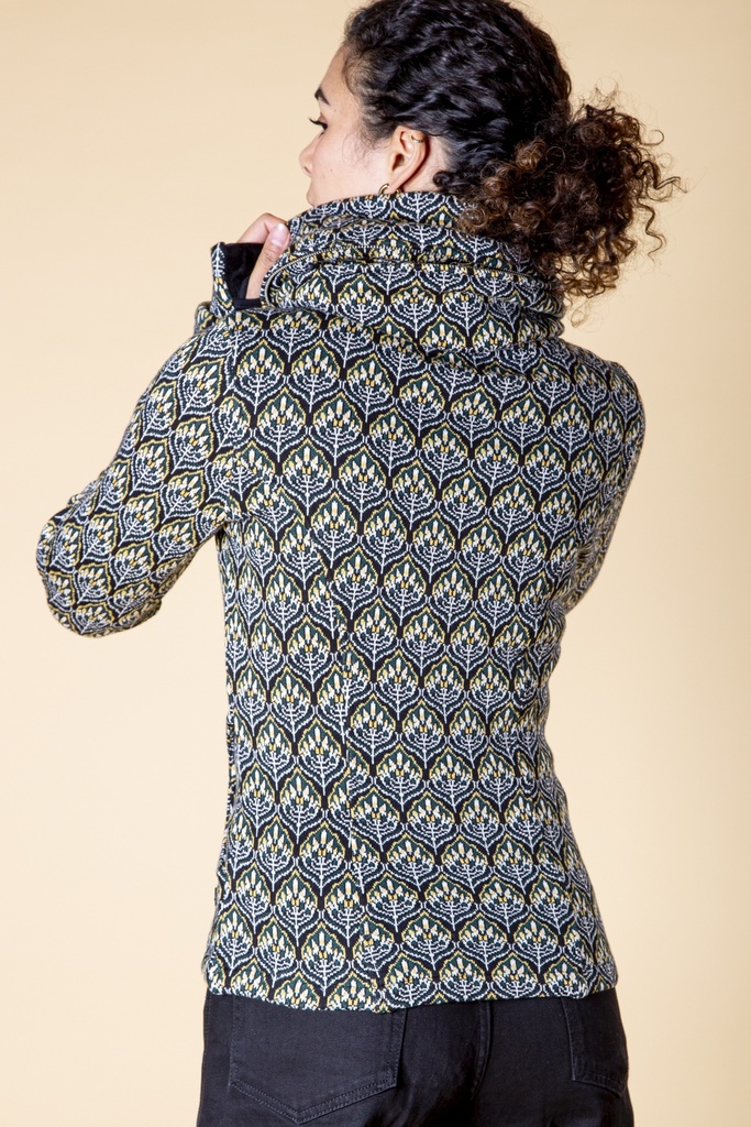Rückansicht bis zur Hüfte: das dunkelblaue Blütenmuster bedeckt den Rücken der Strick-Jacquard-Jacke bis zum breiten Kapuzenkragen.