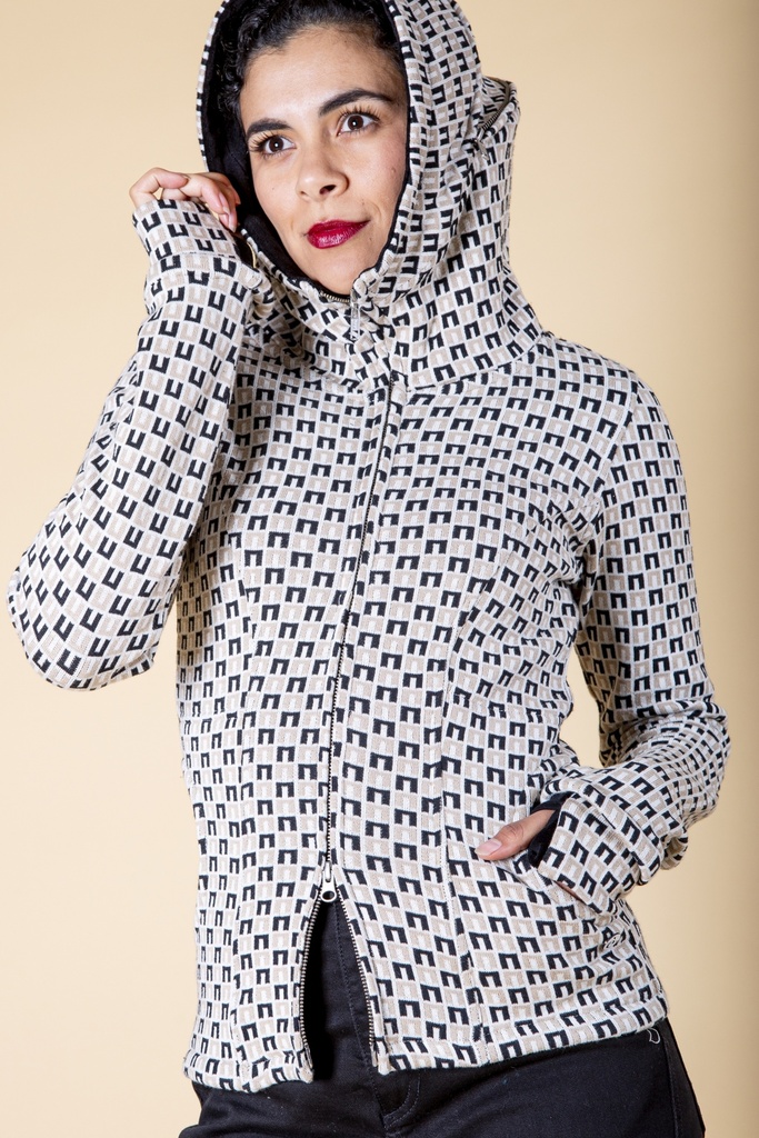 Vorderansicht mit aufgesetzter Kapuze: die weiß-schwarz gemusterte Strick-Jacquard-Jacke zeigt Reißverschluss, Eingrifftasche und dunkle Ärmelstulpe.