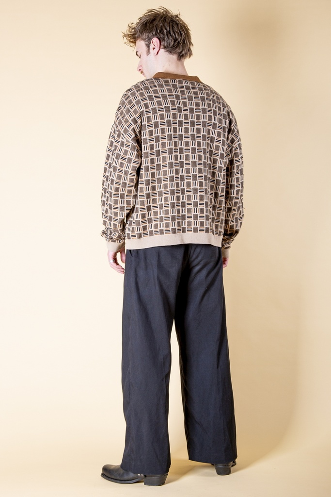 Ganzkörper-Rückansicht: Das beigebraune Poloshirt mit grafischem Jacquardmuster ist gerade geschnitten und zeigt braune Bündchen am Saum.