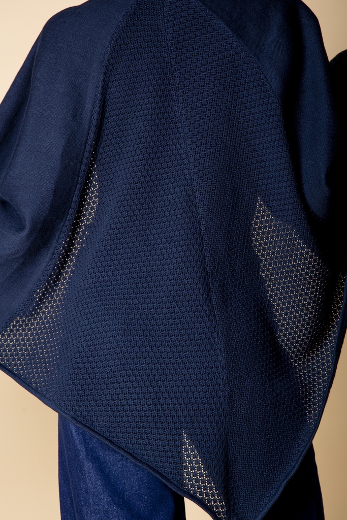Nahaufnahme der Seitenkante: dicht gestrickte dunkelblaue Fläche trifft auf ein durchbrochen gehäkeltes Rückenteil und einen spitzen Saum.