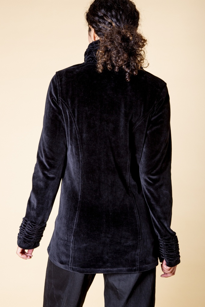 Rückansicht bis zur Hüfte: die schwarze Samtjacke zeigt geschwungene Ziernähte, der hohe Kragen steht am Nacken und die Stulpen sind gerafft.