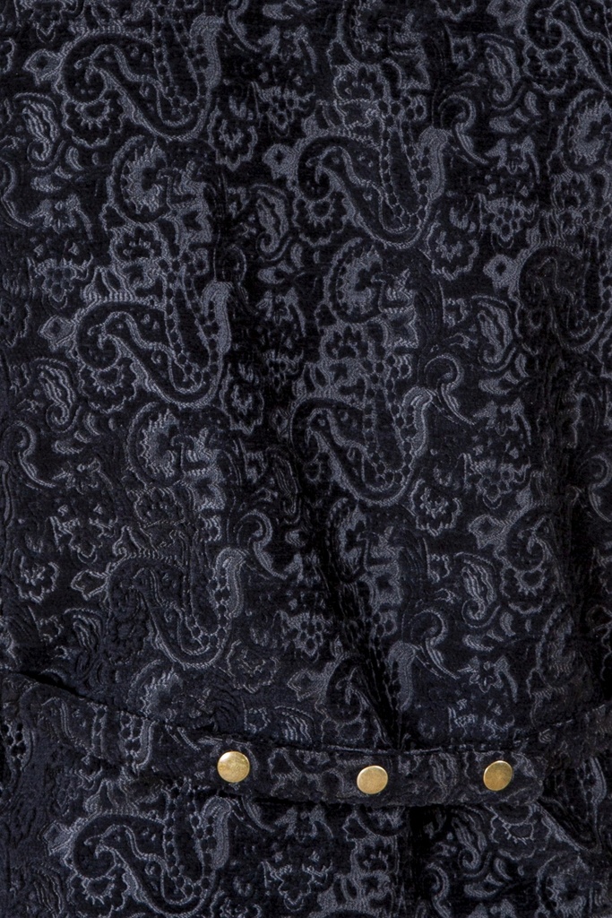 Makroaufnahme der Vorderseite: silbergraue Paisley-Ornamente umgeben die goldfarbenen Druckknöpfe oberhalb der aufgesetzten Eingrifftasche.