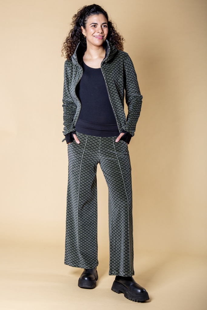 Ganzkörperansicht mit geöffneter Jacke: die schwarz-graue Samthose zeigt ihr durchgängiges Rautenmuster, Biesen und gerade fallende Beine.