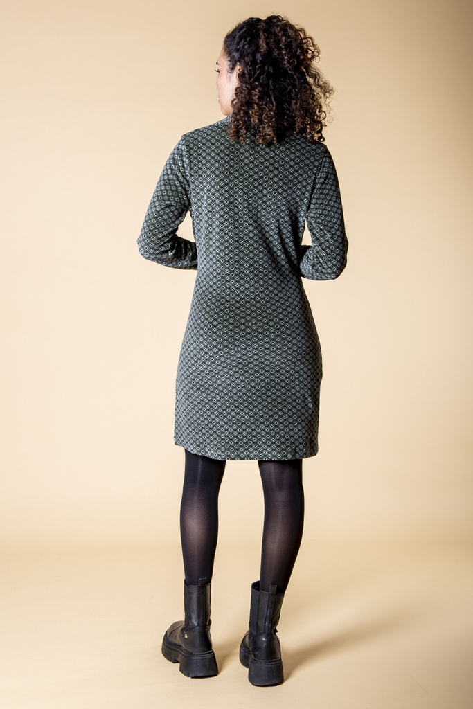 Ganzkörperansicht von hinten: Das schwarzgraue Kleid aus Samt zeigt die gerade, knielange Form, die langen Ärmel und das feine Rautenmuster.