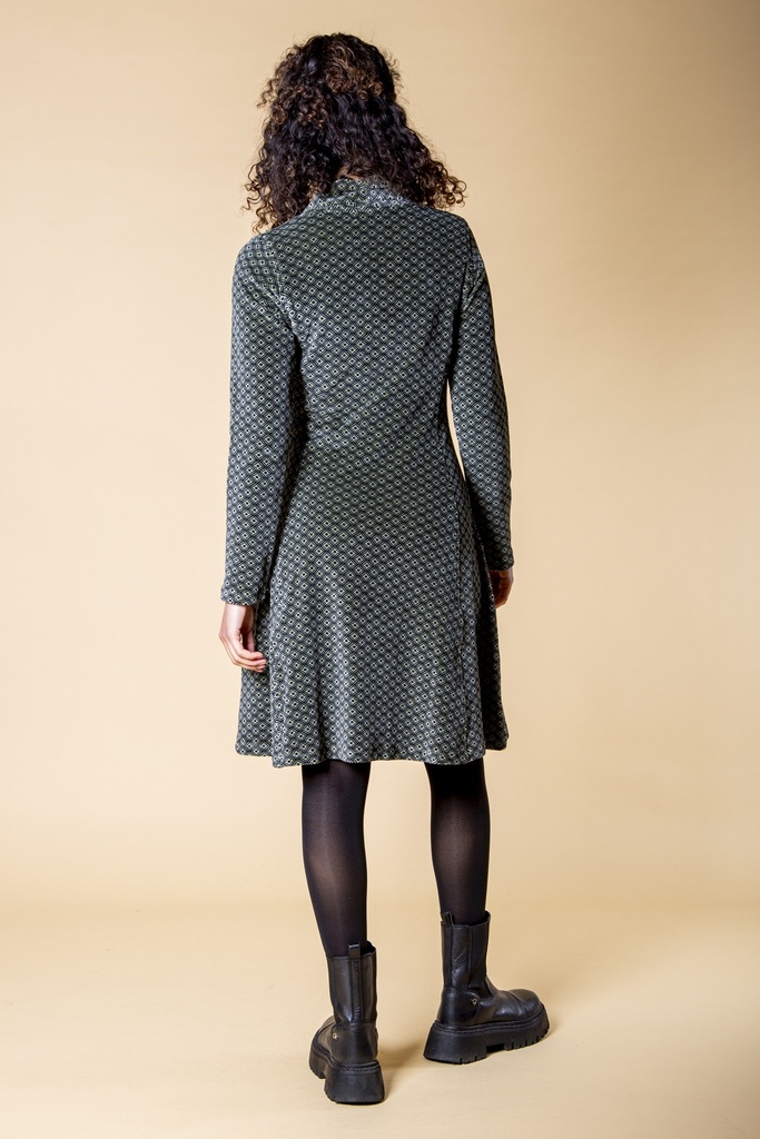 Ganzkörperansicht von hinten: Das schwarzgraue Kleid aus Samt zeigt die taillierte Form, die langen Ärmel und den ausgestellten Rock mit Rautenmuster.