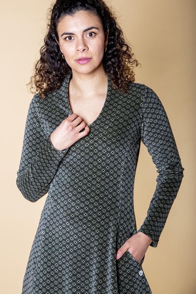 Halbnahe Ansicht von vorn: Das schwarzgraue Kleid aus Samt zeigt den V-Ausschnitt, die langen Ärmel, das feine Rautenmuster und die seitliche Eingrifftasche.